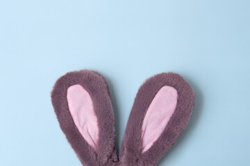 Top view of fluffy bunny rabbit ears on blue background. Easter minimal concept.