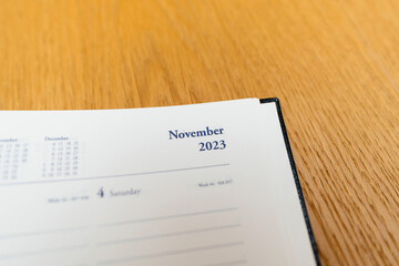 New 2023 year planner agenda with November 2023 empty month - wooden table background