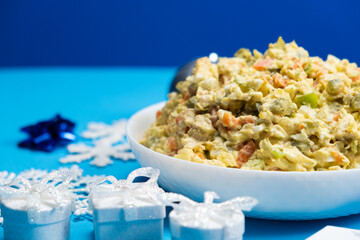 Olivier Russian salad, Christmas and New Year food, blue background.