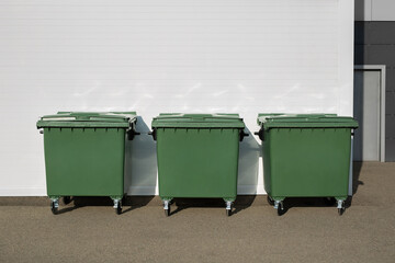 Three green dumpsters on the street. Garbage bin.