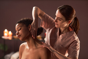 Masseuse massaging neck of young woman that prevents tension and pain