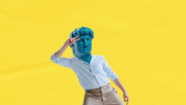 Stop motion, animation. Young man in classical clothes headed by blue antique statue head dancing on yellow background. Contemporary colorful art collage. Concept of art, business, comparison of eras