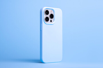 iPhone 14 and 13 Pro Max in light blue case back side view isolated on blue background, phone cover...