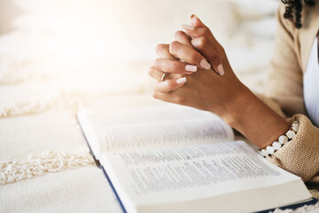 Prayer, bible and hands praying for religion, hope or help, spiritual or faith in home. God, christian and female or woman worship Jesus Christ or Holy Spirit with catholic text or book for peace. - obrazy, fototapety, plakaty