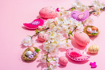 Gentle Easter composition with cherry flowers and handmade felt birds. Decorative eggs and nest