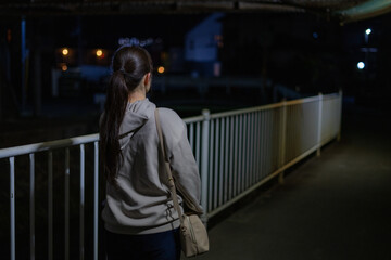 夜道を歩く女性の後ろ姿