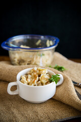 cooked dumplings with potatoes and fried onions on a wooden table.