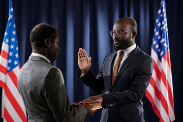 Young confident president of United States giving oath of office during inauguration ceremony with...