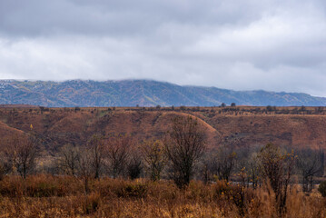 Amazingly beautiful autumn landscapes of a mountainous area located in northern China. Rainy landscape with clouds on top of mountains. Beautiful non-tourist routes. Exploring new places.
