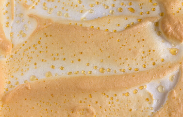 Appetizing background showing a close-up of a browned meringue with precipitated droplets of melted sugar. Top view of homemade cheesecake with dew. copy space.