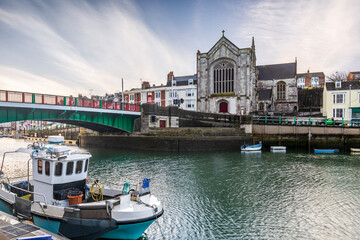 Fototapeta premium A fishing boat moored in Weymouth Harbour in Dorset, with the Old Town Bridge and Holy Trinity Church in the background.