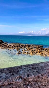 beach and sea with rocks under a Clear Blue sky