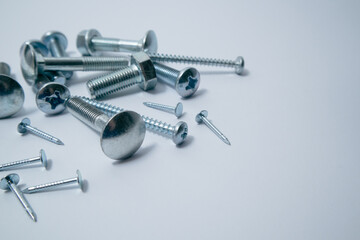 Set of bolts, screws, nails on a white background. Construction abstraction. Industrial background. Screws and bolts macro photo, screw background, steel screw, bolt macro.