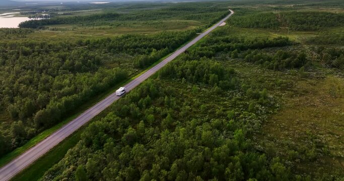Aerial view following a RV driving in polar wild, summer day in Kaldoaivi wilderness area, Finland