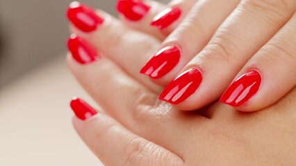 Female hands with fashionable manicure of red color . Woman shows her new red manicured nails, closeup. Beauty of nails. Classic red manicure.