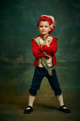Portrait of cute little boy dressed up as medieval character, little prince and pageboy posing over...