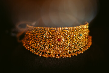 Close up shot of beautiful gold necklace jewelry isolated on black background. Authentic Traditional Indian Jewellery Necklace On Dark Background. Wedding and Festivals concept.