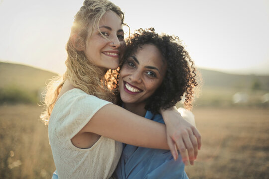 two young women in the countryside embracing