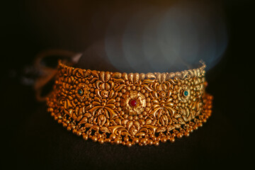 Close up shot of beautiful gold necklace jewelry isolated on black background. Authentic Traditional Indian Jewellery Necklace On Dark Background. Wedding and Festivals concept.