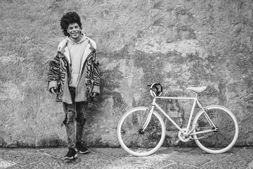 Young african boy having fun with his bicycle outdoor in the city - Soft focus on face - Black and white editing