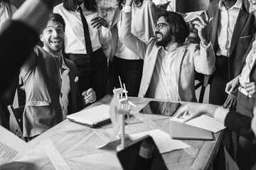Happy business people celebrating renewable energy project success at office - Soft focus on arabian man - Black and white editing