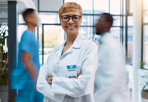 Portrait, doctor and black woman in a busy hospital standing arms crossed with motion blur. Healthcare, leadership and trust with a female medicine professional in a clinic for health treatment