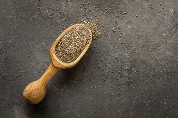 Chia seeds ( Salvia Hispanica ) in wooden shovel or spoon on rustic background. Cereal healthy food 