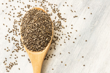 Chia seeds ( Salvia Hispanica ) in wooden shovel or spoon on rustic background. Cereal healthy food 