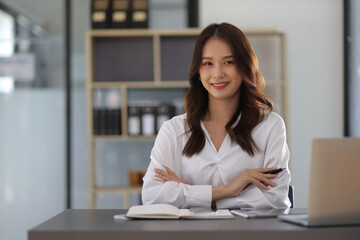 Portrait of beautiful asian business woman working with laptop at desk in office.