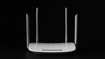 White Wi-Fi router with four antennas on a black background.