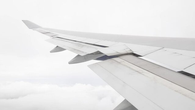 Airplane flying through clouds, over wing window view