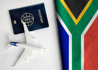 Flag of South Africa with passport and toy airplane. Flight travel concept 