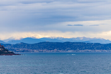 Winter on the Côte d'Azur - view of Cannes with snow covered mountains, Provence, France