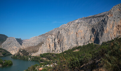Fototapeta na wymiar Views of the lake from the King's Trail (El Caminito del Rey). Mountain trail along steep cliffs in Chorro Gorge, Malaga, Andalusia, Spain.