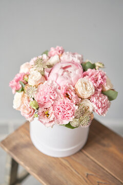 Beautiful spring bouquet in round box. Arrangement with various flowers. The concept of a flower shop. A set of photos for a site or catalogue. Work florist.