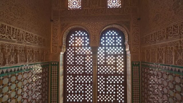 Camera moves to arches of the window between the walls with Moorish ornaments. Magnificent moorish interior in Alhambra palace, Granada. Gimbal shot, 4K