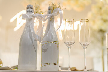 Fototapeta na wymiar Glasses and a bottle of champagne bride and groom on the festive table newlyweds. Happy Wedding day.