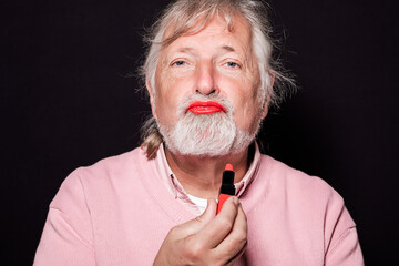 senior man with lipstick pouts looking at camera