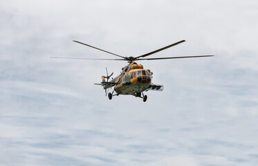 Military helicopter in the cloudy sky.