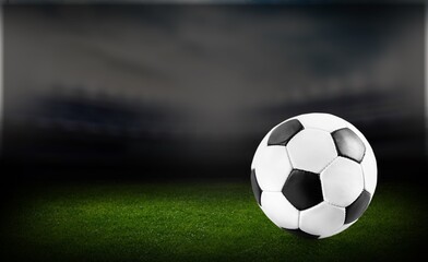 Naklejka na ściany i meble Official football ball on green stadium grass