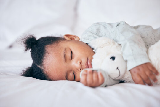 Black child, baby and sleeping with toy in bedroom, home and nursery for peace, calm nap and dreaming. Tired young girl kid asleep with teddy bear for resting, break and healthy childhood development