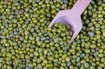 Green Asian beans with a wooden spoon. Green mung beans. Source of vitamins and protein. Bean texture.