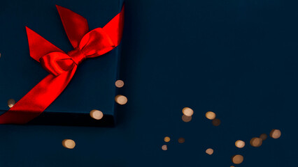 blue gift box with a red bow on blue background.
