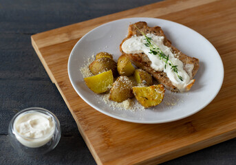 Baked potatoes with roasted meat and sauce