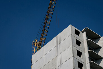 Fototapeta premium Crane and building construction site against blue sky