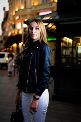 Fototapeta premium Woman wearing casual clothes walking in warm autumn evening city
