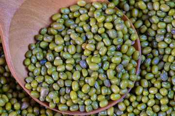 Green Asian beans on a wooden background.Green mung beans. A source of vitamins and protein on the table. Beans on a wooden table in a wooden spoon.