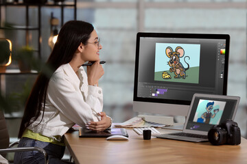 Animator working with computer and laptop. Illustrations on screens - obrazy, fototapety, plakaty