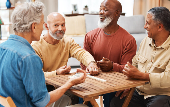 Senior men, friends and dominoes in board games on wooden table for activity, social bonding or gathering. Elderly group of domino players having fun playing and enjoying entertainment at home