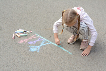 Fototapeta na wymiar Little child drawing happy family with chalk on asphalt